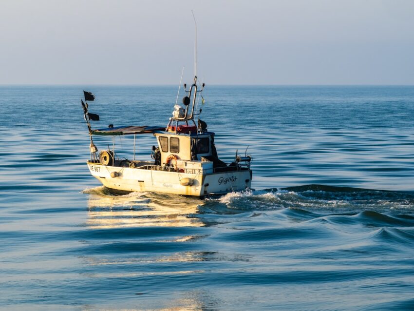 Angler on an offshore boat is engaged in a powerful battle, reeling in a large yellowfin tuna from the deep blue sea, with...