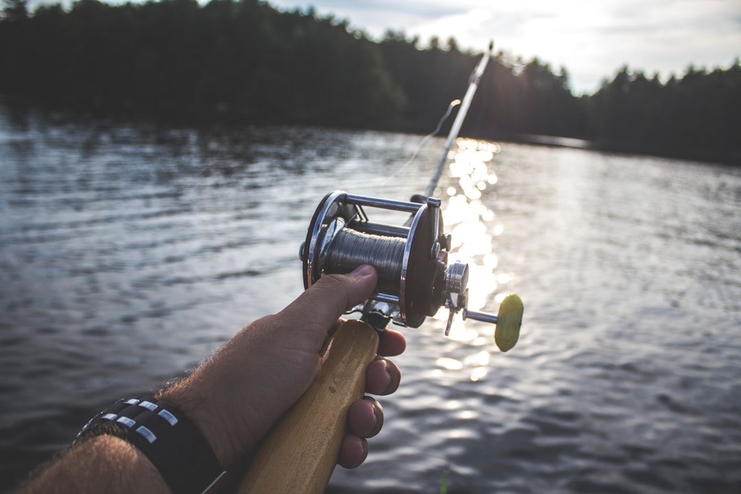 An action shot of a fisherman on a boat, actively reeling in a large, fighting fish, showcasing the successful result of a data-driven fishing strategy.