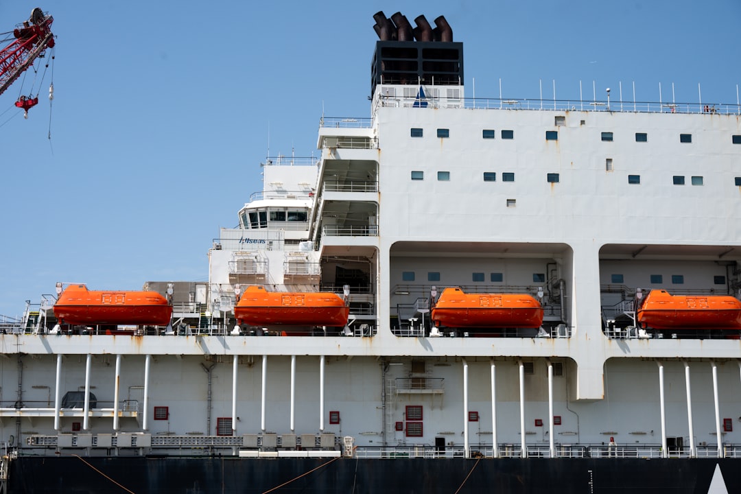 A small, agile fishing boat navigating the open ocean near a massive ship, symbolizing the 'giant killer' tactic of using smart strategy to compete against larger rivals.